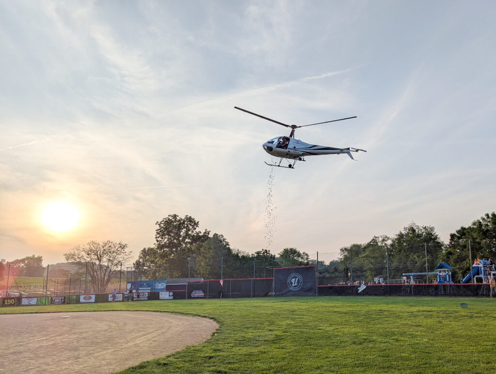 helicopter dropping golf balls at the URA Baseball helicopter golf ball drop