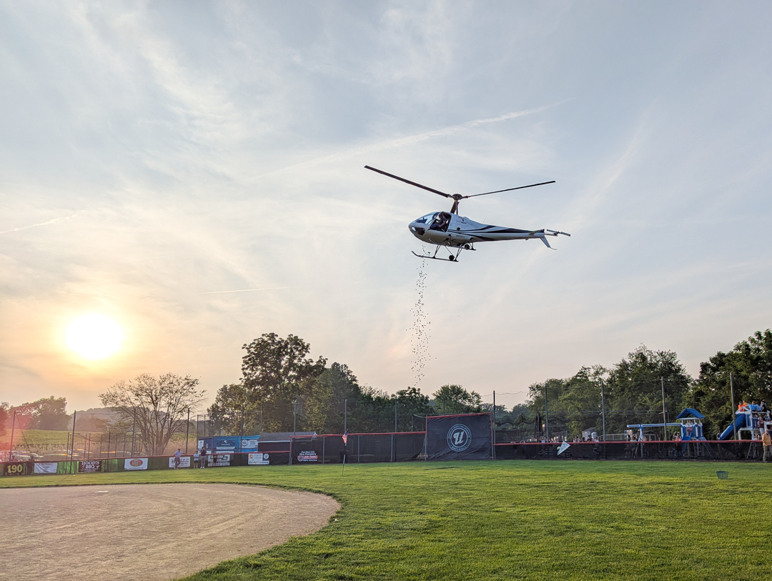 helicopter dropping golf balls over a baseball field