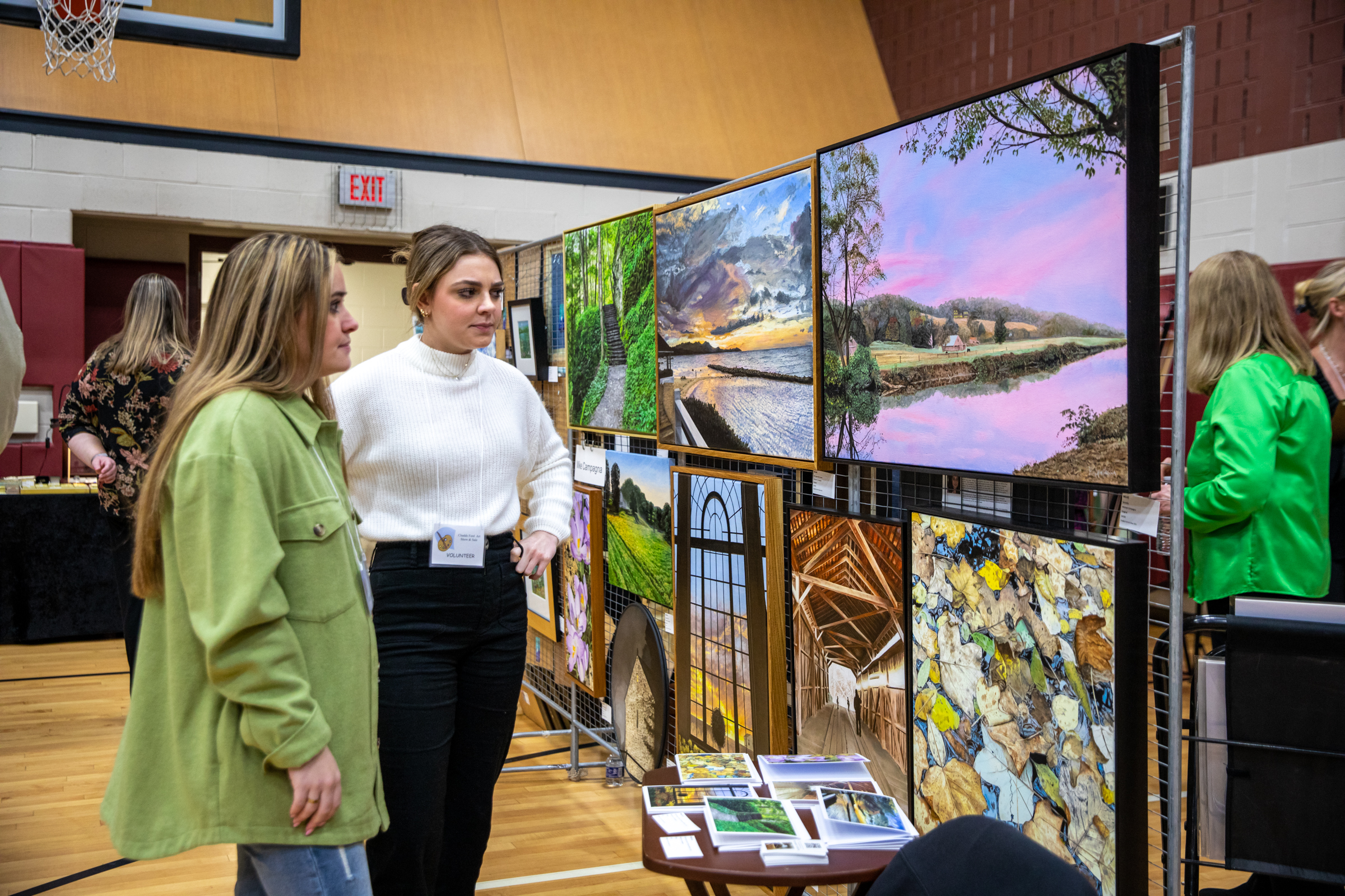 two women looking at art at the art show