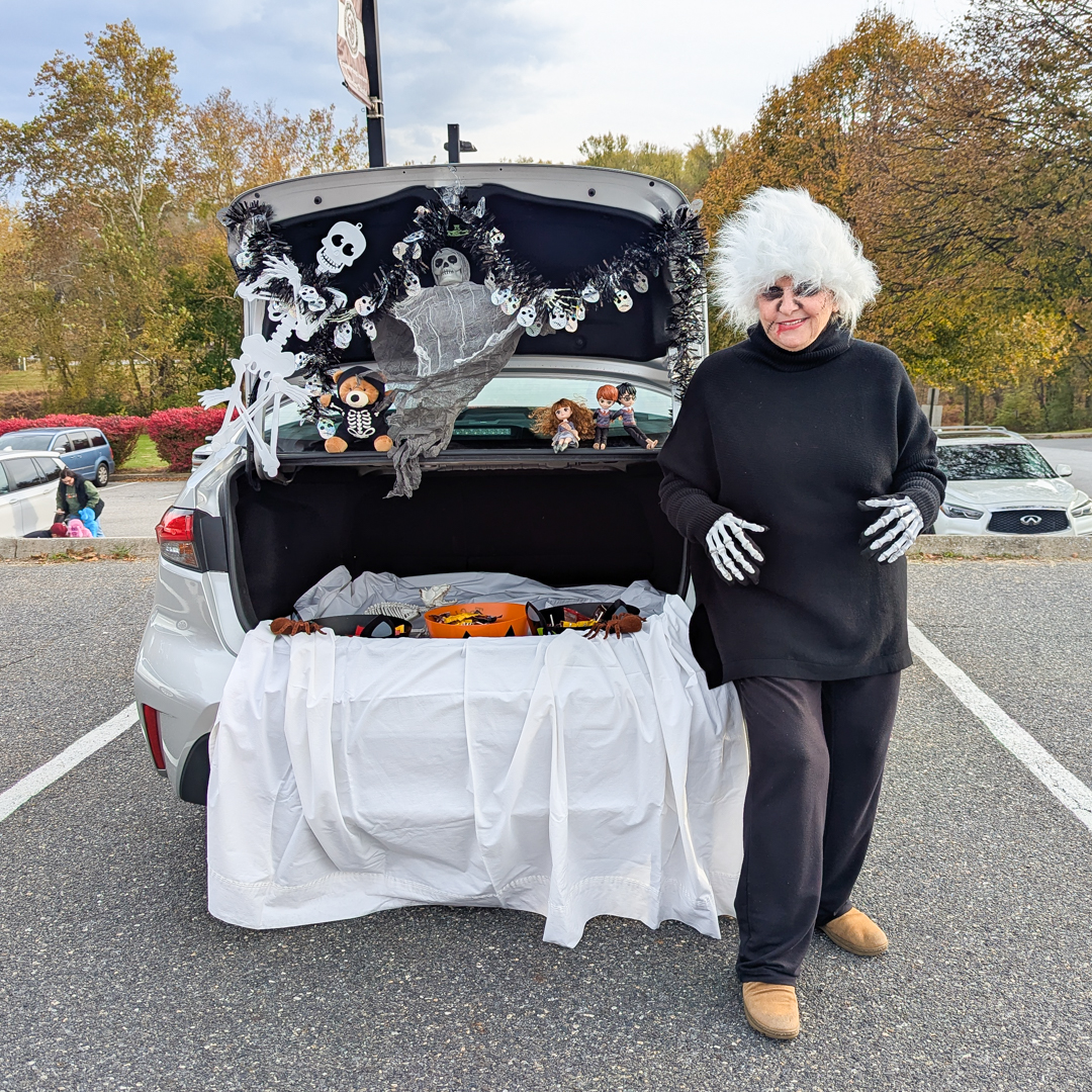 Black and whilte themed skeleton trunk; woman who decorated the trunk is dressed as a skeleton and standing next to trunk
