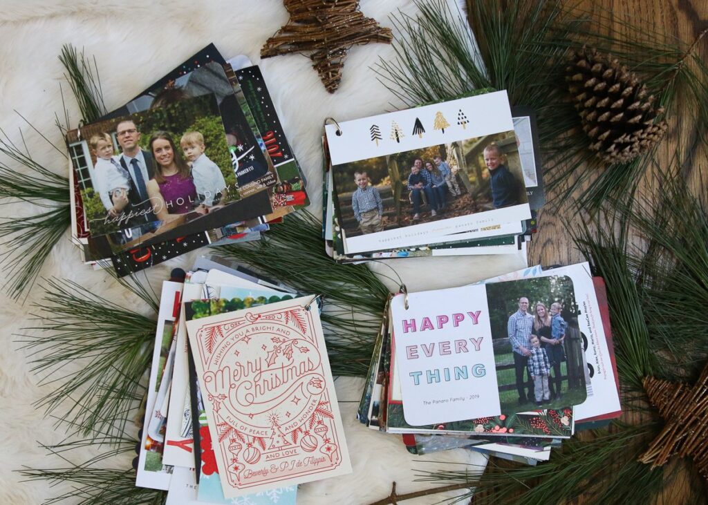 four piles of holiday cards, each clasped together with a metal ring to save for future years