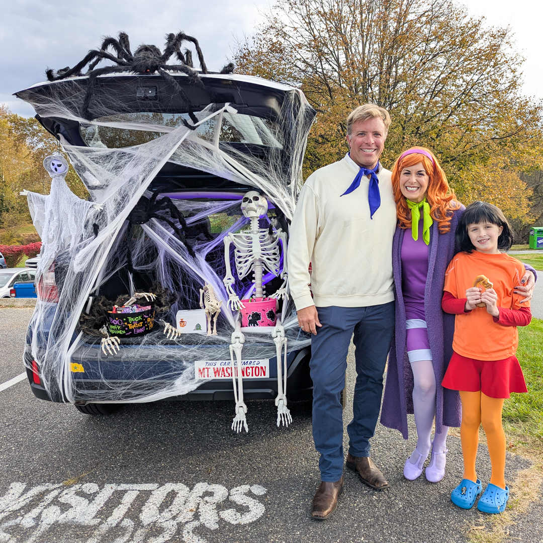 Scooby Doo family costume with trunk covered in spiders webs and a big skeleton